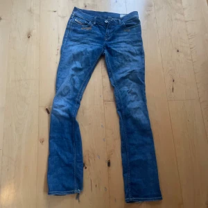 Blå jeansbyxor från Diesel LIV - Säljer ett par lågmidjade, klassiska blå jeansbyxor från Diesel, modell LIV. Byxorna har normal passform, raka ben och klassisk femficksdesign. Tillverkade i stretchigt denim för extra komfort. Perfekta till vardagsstilen.