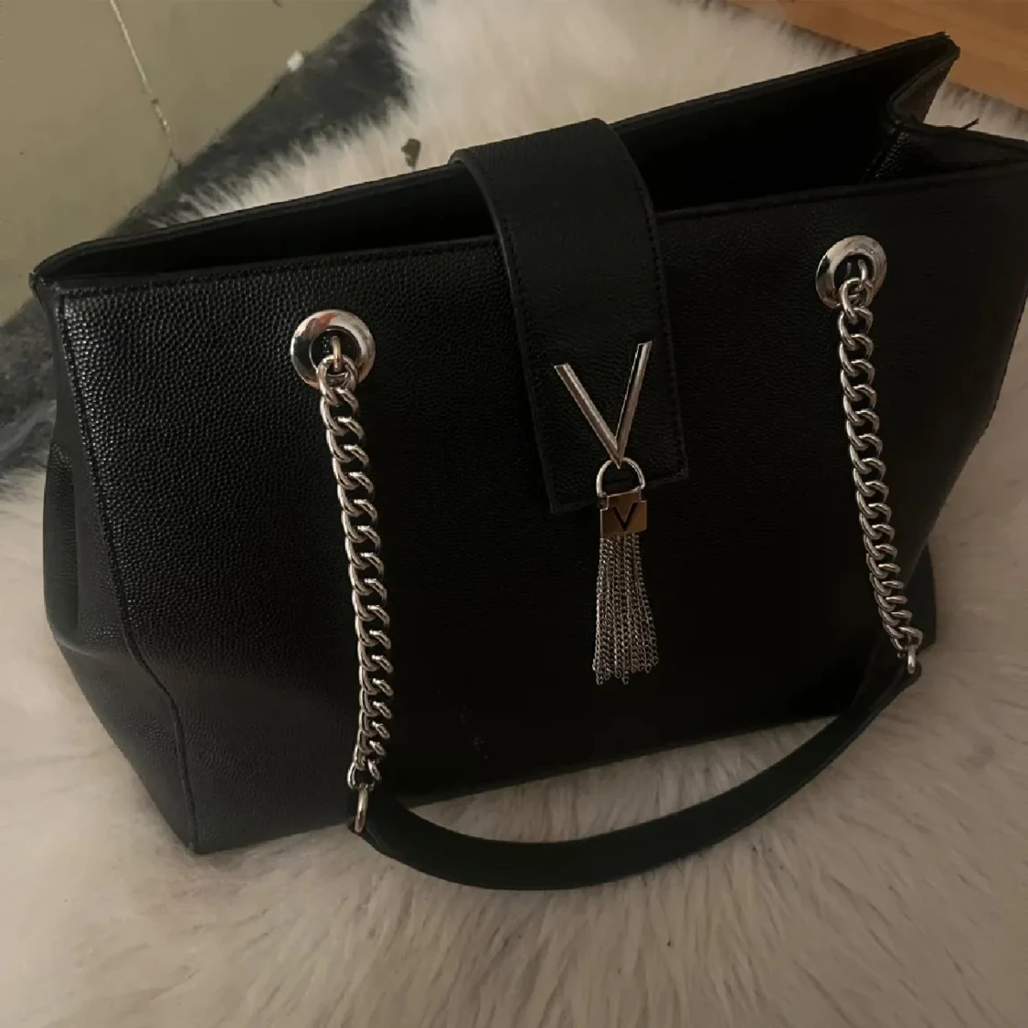 Svart handväska med kedjerem och tofsdetalj - 1