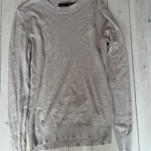 Beige stickad tröja  - En enkel och stilren beige stickad tröja  med rund halsringning och långa ärmar. Perfekt för lager-på-lager och passar till det mesta. Mjuk och skön känsla.