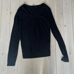 Svart v-ringad ribbad tröja  - Säljer en svart långärmad tröja ribbad med v-ringning. Enkel och stilren modell som passar perfekt till många olika outfits. Mjukt material och bekväm passform.