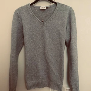 Ljusgrå stickad tröja från VILA - Säljer en ljusgrå stickad tröja från VILA med v-ringning. Väldigt rik, mjuk och sjönt material. Perfekt för lager-på-lager och enkel att matcha med olika outfits. 🍁🫶🏼