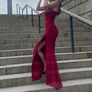 Vinröd långklänning med slits - Säljer min fina balklänning då den tyvärr inte kommer  till någon användning. Har bara använts en gång och ör i superbra skick!! Skriv gärna privat om ni har några funderingar!! Köpt från Club L London för 1500 + tull ❤️❤️ Möts gärna upp i Göteborg men kan även skicka!!