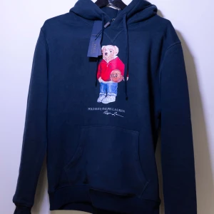 Polo Ralph Lauren Bear Hoodie - Helt ny Polo Ralph Lauren Hoodie med en björn på bröstet. Tröjan har huva och magficka. Perfekt för dig som gillar streetwear och klassiska märken. Kom gärna med frågor😄