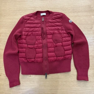 Moncler Tricot Cardigan  - Hejsan, säljer nu en röd moncler tricot cardigan i storlek xs. Den är använd ett fåtal gånger och är i mycket bra skick. Vid frågor är det bara att höra av er!