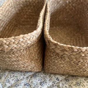 Flätade korgar i naturmaterial - Säljer ett set med fem flätade korgar. 2 st stora och 3 små!! Sedan en liten flätad förvaringslåda (den har lite gul målarfärg på sin jg ska försöka få bort annars borde man inte tänka på det så mycket) Perfekta som accessoarer för förvaring eller dekoration. Korgarna har en naturlig beige färg och är tillverkade i ett robust, flätat material som ger en stilren och bohemisk känsla. Säljer allt ihop tillsammans för 99kr!