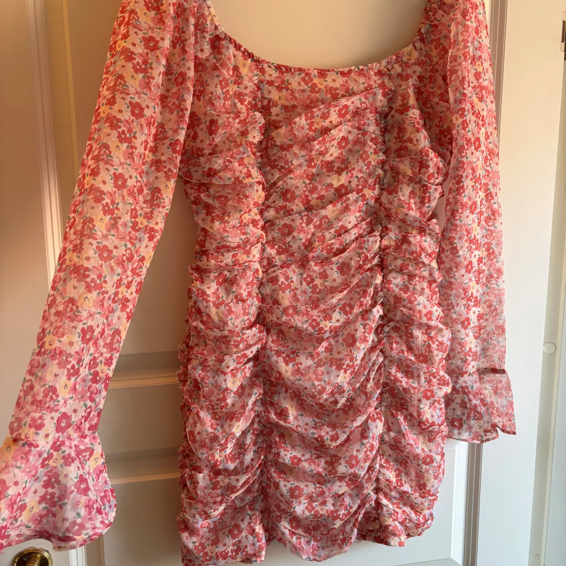 Blommig rosa långärmad klänning med volang