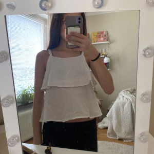 Vit volang-linnetopp från United Colors of Benetton - Säljer en söt vit linnetopp med volang från United Colors of Benetton. Toppen har tunna axelband. Kom inte på håg vart jag köpt. Det står tyvärr ingen storlek. 