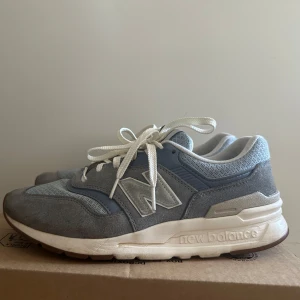  New Balance 997 sneakers - Säljer ett par blåa New Balance 997 sneakers med vita snören och detaljer i mocka och syntet. 