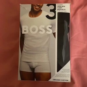 3 pack T-shirt med rund hals från BOSS - Klassisk vit t-shirt med rund hals från BOSS i regular fit. Tillverkad i ekologisk bomull för en mjuk och bekväm känsla. Perfekt basplagg med stilren design och diskret logga.