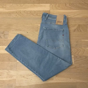 Replay Jeans - Säljer ett par Replay Hyperflex Anbass jeans i ljusblå tvätt. Modellen är anbass med klassiska fem fickor, snygg färg och snygga sömdetaljer på bakfickorna. Inga defekter utom två små gula fläckar som knappt syns. Längden är L30-L28 eftersom att de är uppsydda och bredd W31. Priset ej hugget i sten och hör av er vid minsta fundering🙌