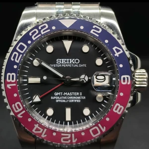Seiko GMT-Master II klocka med blå-röd bezel - Snygg Seiko GMT-Master II med svart urtavla, blå och röd vridring samt datumvisning. Klockan har silverfärgat armband i metall och tydliga indexmarkeringar. Perfekt för dig som gillar klassisk design med sportig känsla.