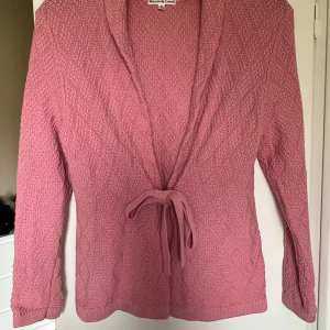 Rosa stickad kofta från Sincerely Loved - Aldrig använd. Inköpt på gekås 129:-. Mysig rosa stickad kofta från Sincerely Loved i storlek M. Koftan har långa ärmar, knytband i midjan och en mjuk struktur. Perfekt för lager-på-lager och enkel att matcha med olika outfits.