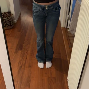 Blå bootcut jeans med låg midja - säljer ett par jätte låg midjade jeans från gina som inte finns kvar längre. jeansen är mörk blåa och aldrig andvända pga för små. pris kan diskuteras. storlek 152 men ganska långa i storleken.
