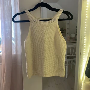 Krämvit stickad topp från Lindex - Säljer en söt krämvit stickad topp från Lindex barnavdelning. Toppen har en fin stickad struktur med en liten öppning i ryggen. Det är 2 knappar uppe i nacken som fäste. Använd max 3 gånger 💓