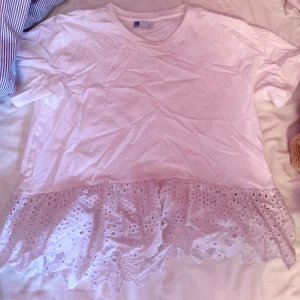 Vit topp med spetsdetaljer  - Säljer en söt vit topp från Me Style i storlek S. Toppen har korta ärmar och en vacker spetsdetalj längst ner. Aldrig använd ( ligger bara i garderoben därför är den skrynklig) 