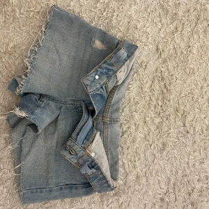 Blå jeansshorts - Snygga blå jeansshorts från Mango med snygg slitning. Lånade bilder då jag köpte de här på Plick men de inte passade. Nypris: 300kr Storleken är 146, vilket motsvarar xxs och midjemåttet rakt över är 32 cm💕