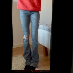 Grå bootcut jeans med slitningar - Snygga grå bootcut jeans med slitningar på knäna. Storlek 24/32. Supercoola och passar super snyggt till, till exempel stickade tröja mm. Intressekoll därför går det inte att köpa direkt, om många är intresserade kommer jag lägga ut en ny annons där det går att köpa direkt😊