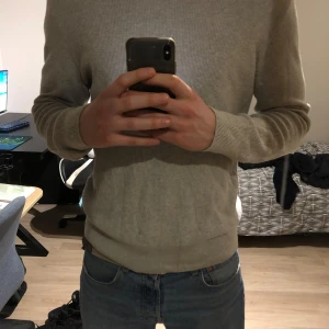 Stickad tröja från Zara - Säljer en stilren grå tröja från Zara. Tröjan har en klassisk design med långa ärmar och rund halsringning. Perfekt för en avslappnad och snygg look. 