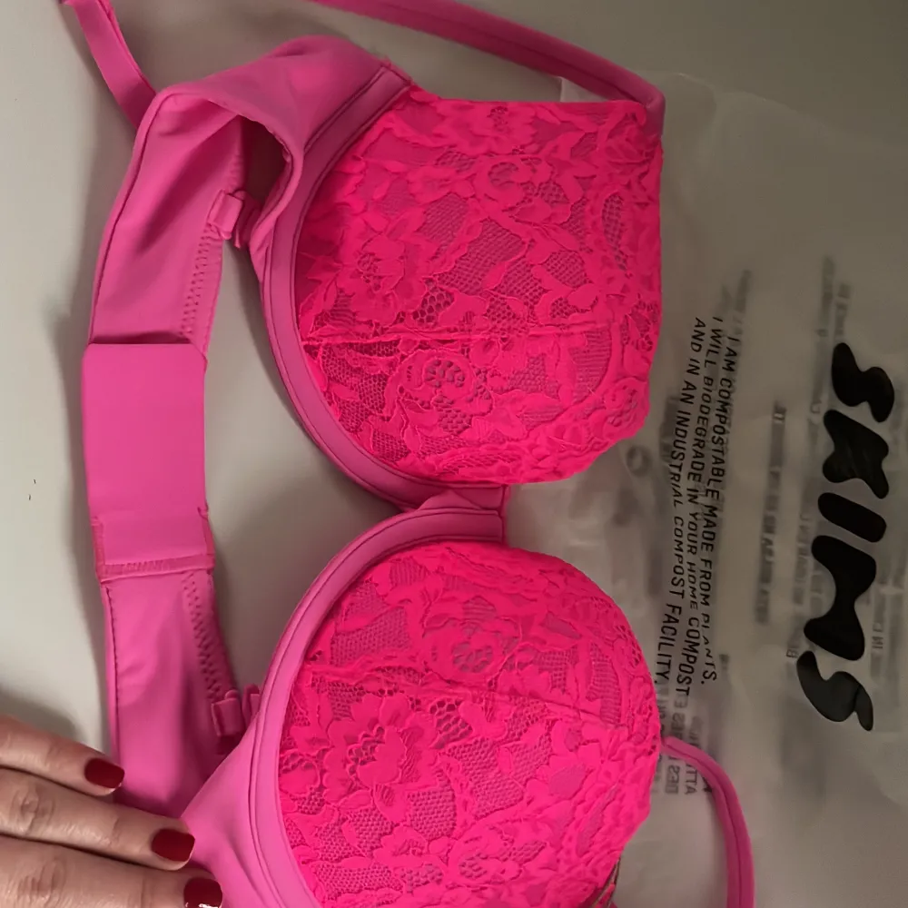 Snygg neonrosa bh från Skims med spetsdetaljer. Perfekt för att ge en färgklick till din garderob. Den har justerbara axelband och en bekväm passform.. Muu.