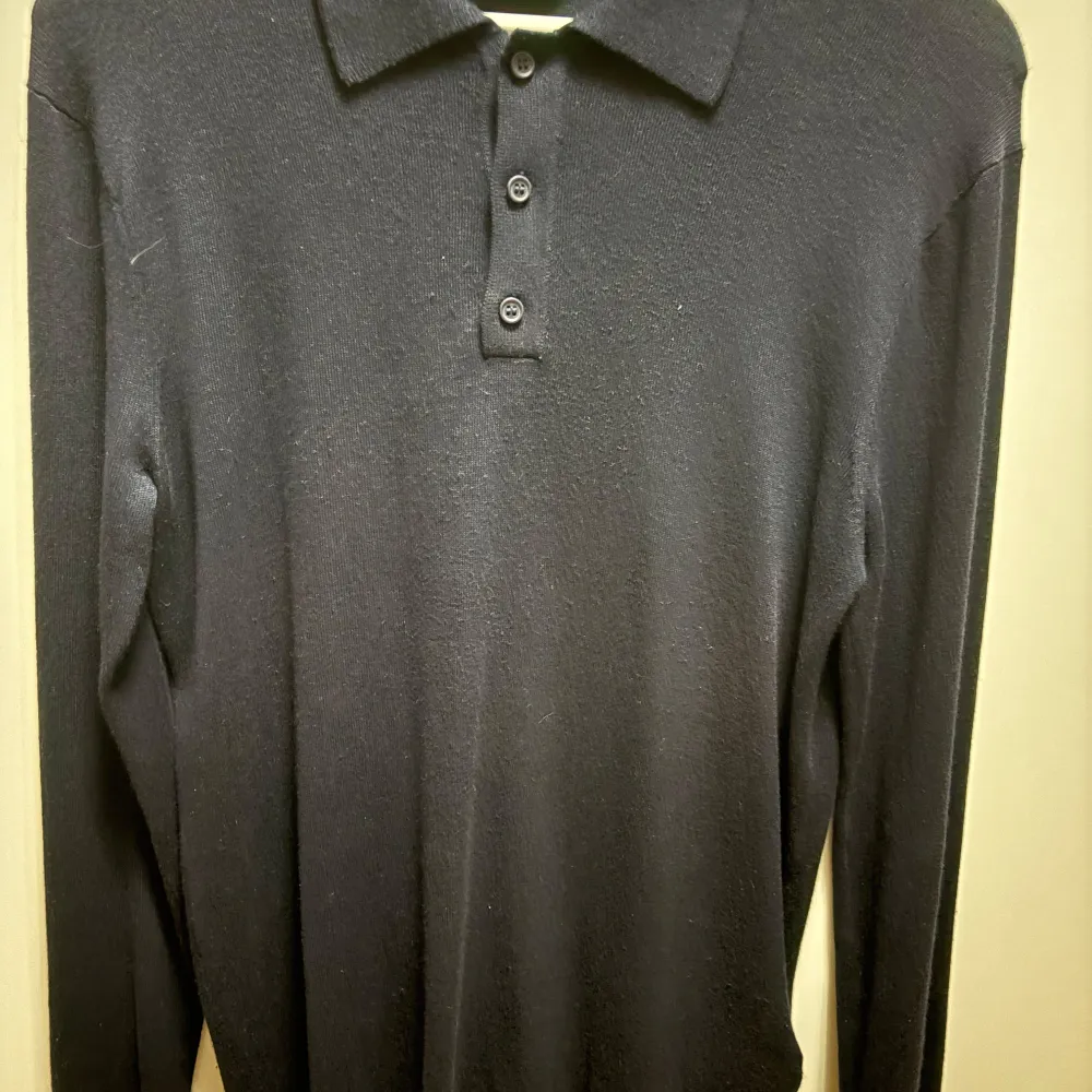 Snygg svart långärmad pikétröja från Only & Sons. Tröjan har en klassisk krage med tre knappar framtill. Perfekt för en stilren look.. Neuletakit & Villapaidat.