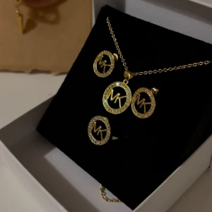 Guldhalsband och örhängen med glittriga detaljer - Elegant set med halsband och örhängen i guld. Helt ny och oanvänd. Ring ingår som i bild, och är justerbar