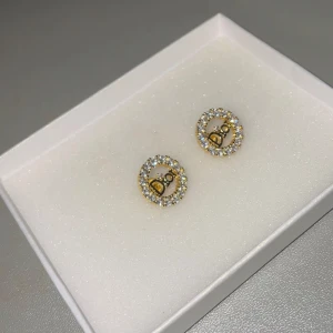 Guldörhängen med glitter - Eleganta guldörhängen med glittrande strass som ramar in en stilren design. Helt ny och oanvänd.