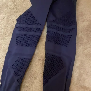 Mörkblå leggings från ICANIWILL - Snygga mörkblå leggings från ICANIWILL med hög midja och ventilerande meshpaneler längs benen. Storlek s. 