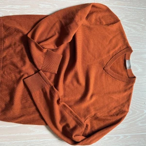 Orange tröja från John Henric - Säljer en snygg orange tröja från John Henric i storlek S. Tröjan har en v-ringad design och är perfekt för höst och vinter. Den är tillverkad i ett mjukt material som ger en bekväm passform.