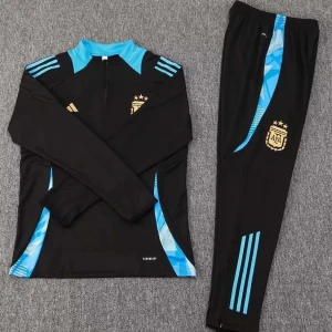 Argentina tracksuit - Snygg svart långärmad fotbollströja från Adidas med blå detaljer och guldemblem på bröstet. Tröjan har en halv dragkedja och matchande byxor med blå ränder. Perfekt för träning eller avslappnad stil.