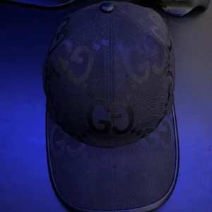 Gucci keps - Snygg Gucci keps med det ikoniska GG-mönstret. Kepsen har en justerbar rem baktill för perfekt passform. Perfekt för att ge din outfit en lyxig touch.