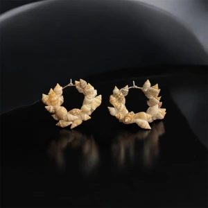 Örhängen med snäckor - Unika örhängen dekorerade med små snäckor i olika beige och bruna nyanser. Perfekta för att ge en naturlig och bohemisk touch till din stil. De har en rund form och är lätta att bära.