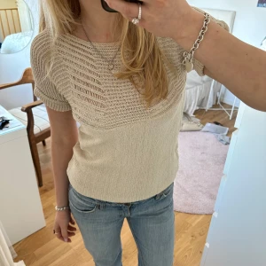 Beige stickad topp - Säljer en beige stickad topp med korta ärmar och ett snyggt ribbat mönster upptill. Har en liten fläck men går nog bort i tvätten🌟