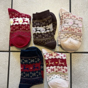 Färgglada julstrumpor med renmönster, paket, storlek 35-38 - Säljer ett set med mysiga julstrumpor i olika färger och mönster. Strumporna har ett charmigt renmönster och finns i färgerna röd, brun, rosa och blå. Perfekta för att hålla fötterna varma under vintern och julen. De är tillverkade i ett mjukt material som känns skönt mot huden.