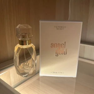 Angel Gold Eau de Parfum från Victoria's Secret - Säljer en elegant Angel Gold Eau de Parfum från Victoria's Secret. Flaskan är stilrent designad med en facetterad kork och rymmer 50 ml. Doften har noter av bergamott, gardenia och mysk, vilket ger en fräsch och blommig upplevelse. Perfekt för den som vill ha en lyxig och feminin doft. Köpt i Italien för 110€ och aldrig använt den