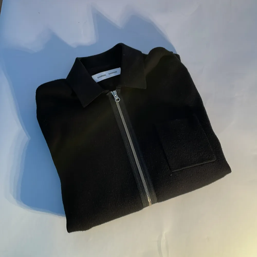 Snygg svart långärmad tjocktröja med dragkedja från samsöe. Väldigt mjukt och skönt matrial kolla bild 4 för att se vad den är gjord av, nästan helt ny och säljer den då den är lite för stor på mig jag är 180 cm lång och väger 70 kg, kom dm vid frågor funderingar eller bud. Neuletakit & Villapaidat.