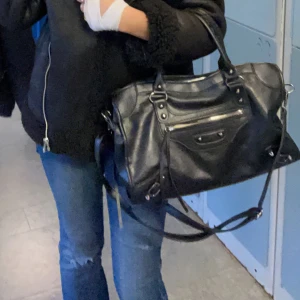 Svart skinnväska - Snygg svart skinnväska med dragkedja och handtag. Perfekt för att bära med sig det viktigaste. Stilren design som passar till många olika outfits. Pris går att diskutera