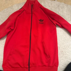 Röd träningsjacka från Adidas - Gammal modell av adidas koftorna, knappt använd då jag köpte dom för länge sen och aldrig använt!