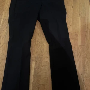 Svarta kostymbyxor från Bik Bok - Snygga svarta kostymbyxor från Bik Bok i klassisk stil. Byxorna har en rak passform och är perfekta för en stilren look. De har diskreta fickor och en smidig dragkedja framtill.