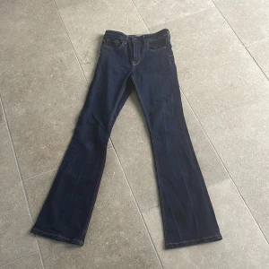 Mörkblå bootcut jeans från Zara - Snygga mörkblå bootcut jeans från Zara med klassisk femficksdesign och kontrastsömmar. Perfekta för en stilren look. Tillverkade i ett slitstarkt denimtyg.