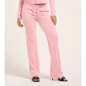 Juicy Couture  - Snygga rosa mjukisbyxor med snörning i midjan och vida ben. Perfekta för en avslappnad stil. Byxorna har praktiska fickor framtill. Med prislapp på