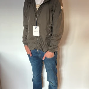 Moncler windbreaker grön  - När regnet faller och vinden vänder – du är redo.  Den här Moncler-jackan är byggd för rörelse, stil och komfort. En av de där jackorna folk kollar två gånger på när du går förbi.  🧊 Lätt fodrad, perfekt för svensk vår/höst 🏷 Storlek:  📦 Skick: Använd men fräsch  Kom och ta stilen innan någon annan gör det.