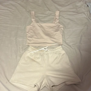 Beiga shorts med snörning från Amisu och en tröja från neworker  - Snygga beiga shorts från Amisu i mjukt bomullsmaterial. De har elastisk midja med vit snörning och praktiska fickor på sidorna. Perfekta för chill dagar eller när du vill ha en clean och enkel look. Passar dig som gillar basic och comfy vibes.