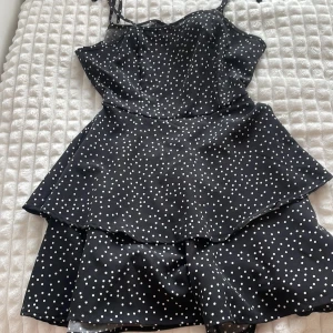 Prickig klänning - En svart klänning med vita prickar i storlek XXS. Den är i nyskick och har aldrig använt den då den är för liten i bysten(därav har ja inga bilder). Man knyter den i ryggen och det är shorts nere som man inte ser när man har på sig klänningen eftersom det blir volangigt nertill. Jag har fått klänningen av min kusin💕💕💕