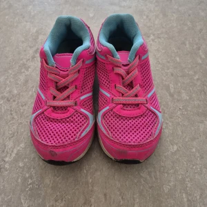 Sneakers - Säljer ett par färgglada sneakers i rosa och turkos med snörning. Skorna har en ventilerande mesh-design och en robust sula för bra grepp. Dom är väl använda. (Men inget hål). Perfekta för aktiva dagar.