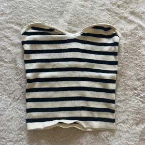 Randig stickad tubtopp - Snygg stickad tubtopp i randigt svart/vit mönster. Toppen är från HM i storlek XS.