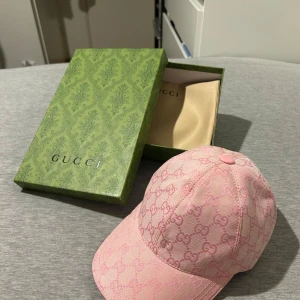 Rosa keps  - Snygg rosa krps. Kepsen är tillverkad i bomull och har justerbar rem baktill för perfekt passform. Perfekt för att ge din outfit en lyxig touch.