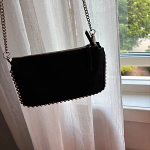 Svart axelväska med silverdetaljer - Säljer min väska från Zara. Den är väl använd och har tappat lite färg på kedjan, därav priset🥰