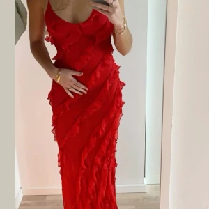 Röd volangklänning med smala axelband - - Pris kan diskuteras vid snabb affär (skicka förslag) - Snygg röd klänning med smala axelband och flera volangdetaljer framtill.  - Klänningen har en v-ringad hals och är ärmlös, perfekt för sommarens alla tillfällen. Lätt och luftig känsla. 