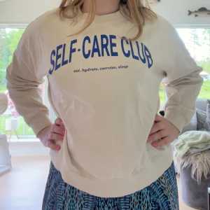 Beige sweatshirt  - Säljer en beige sweatshirt från H&M med blå texten 'SELF-CARE CLUB' framtill. Lite oversized. Tröjan är ganska använd men inga defekter. Skriv vid frågor💕💕
