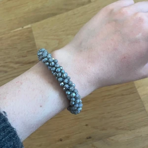 Grått pärlarmband med glittrig yta - Säljer ett snyggt armband med små grå pärlor som har en glittrig finish. Armbandet är elastiskt och har en rund form, perfekt att bära till din vardagsstil för en extra touch. 🔥🔥💗💗💃 köpt på Åhlens😍
